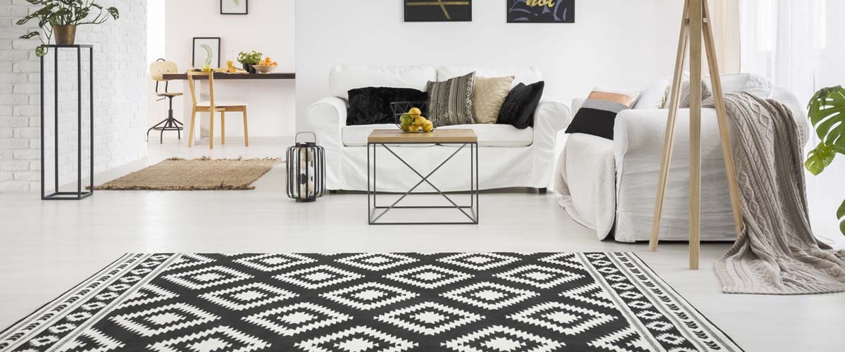 Apartment with white brick wall, sofa, table and pattern rug